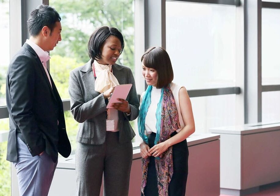 Three businesspeople discussing a tablet.