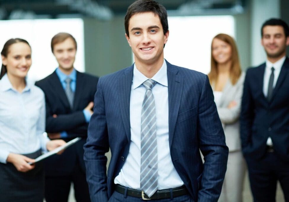 Smiling businessman in a suit with colleagues.