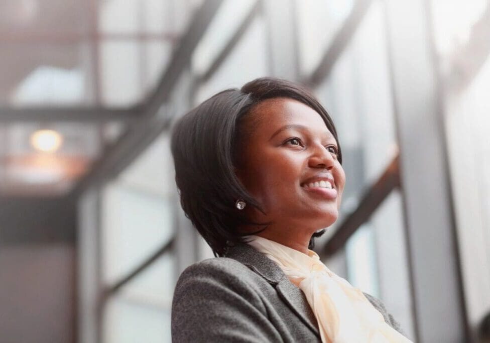 Smiling businesswoman looking up in office.